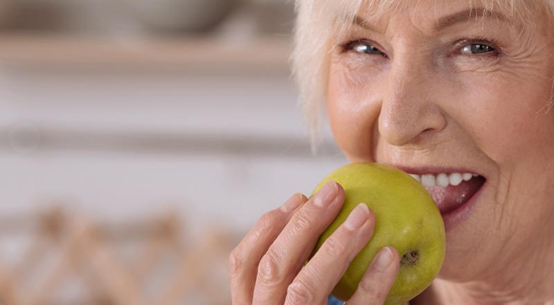 old woman eating apple